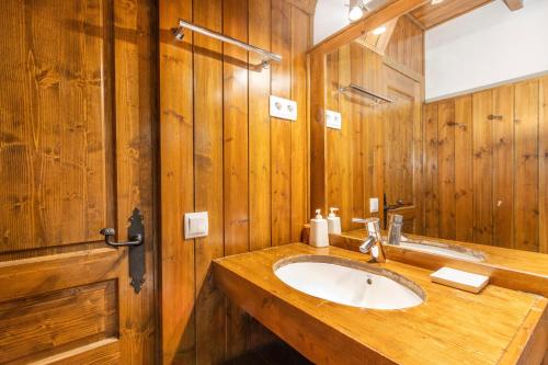 a wooden bathroom with a sink and a mirror at Casa aranesa en centro de Arties in Arties