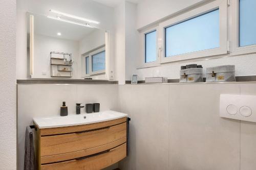 a bathroom with a sink and two windows at Ferienwohnung Wanne im Schwarzwald in Furtwangen