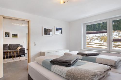 two beds in a room with a couch and a window at Ferienwohnung Wanne im Schwarzwald in Furtwangen