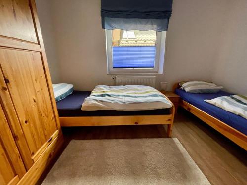 two beds in a small room with a window at Ferienwohnung, Schwerin in Schwerin