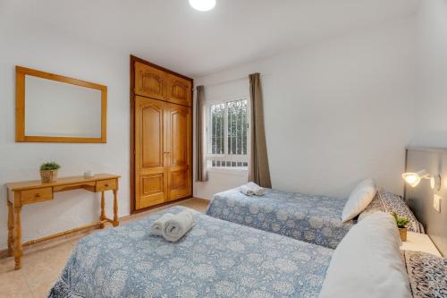 a room with two beds and a table and a window at Sun and Calm Las Floritas in Playa de las Americas