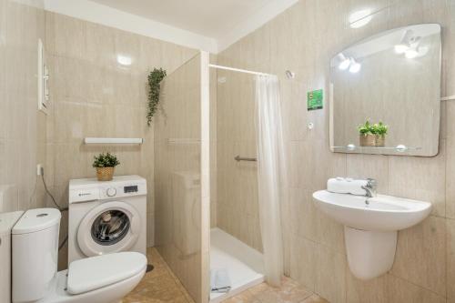 a bathroom with a toilet sink and a washing machine at Sun and Calm Las Floritas in Playa de las Americas
