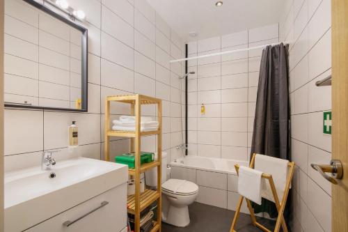 a bathroom with a sink and a toilet and a tub at Casa Viola in Faro