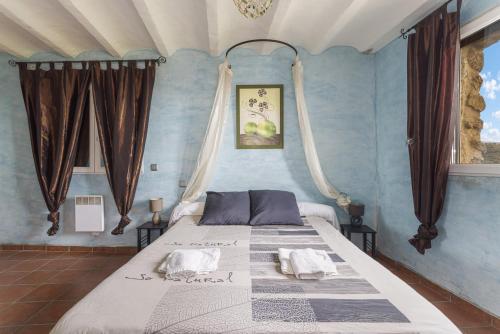 a bedroom with a large bed with blue walls at Tour Catalane in Ille-sur-Têt