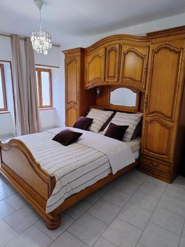 a bedroom with a large bed with a wooden headboard at Gite cozy, Parc naturel du Morvan in Lormes