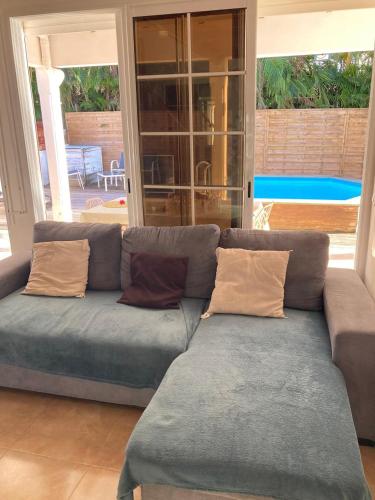 a blue couch with pillows in a living room at Villa SELAH in Le Moule