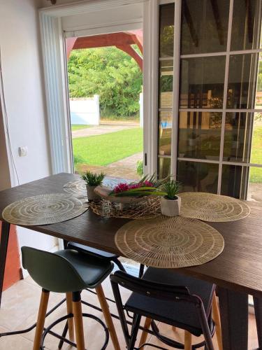 a dining room table with two chairs and a table with plants at Villa SELAH in Le Moule