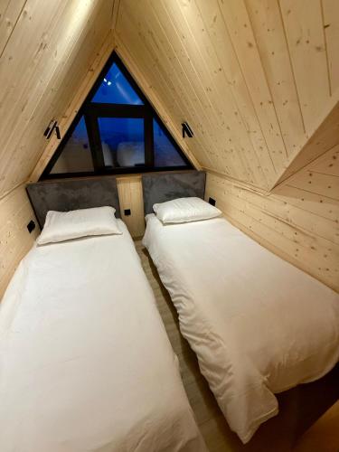 two beds in a small room with a window at Dom z Widokiem na Tatry- Luxury Chalet in Klikuszowa