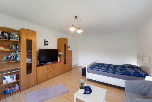 a bedroom with a bed and a tv and a couch at Ferienwohnung Waldblick in Remscheid