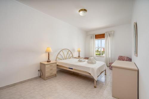 a white bedroom with a bed and a window at Maralvor 301 in Alvor