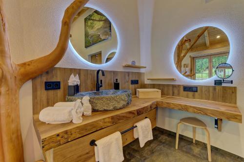a bathroom with a sink and two circular mirrors at Luxus-Chalet Mühlberg in Eppenschlag