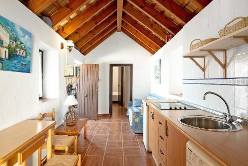 a kitchen with a sink and wooden ceilings at Silla Vieja Uno in Vejer de la Frontera