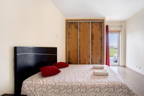 a bedroom with a large bed with red pillows at A O - Apartamento Gâmboa in Peniche
