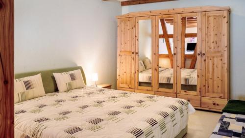 a bedroom with a bed and a large wooden cabinet at Ferienwohnung Strempel in Templin