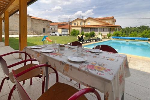 a table with a table cloth on it next to a pool at Casa da Marquinhas - Turismo Rural in Lama de Ouriço