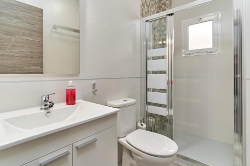 a bathroom with a toilet and a sink and a shower at Nerja Boutique 102 Deluxe in Nerja
