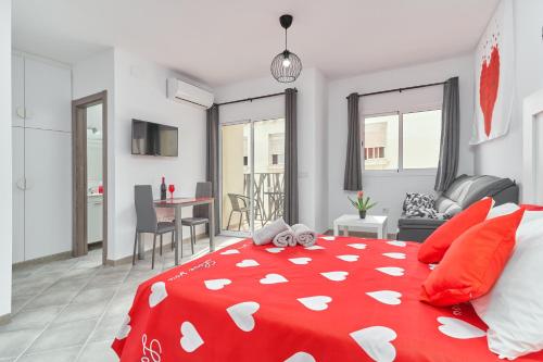 a bedroom with a red bed and a living room at Nerja Boutique 102 Deluxe in Nerja
