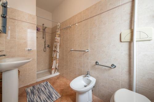 a bathroom with a toilet and a sink and a shower at Casa Vacanze 21 Aprile - 1 in Calasetta