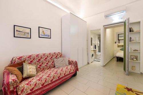 a living room with a red couch and a bedroom at Smart Home Loano in Loano