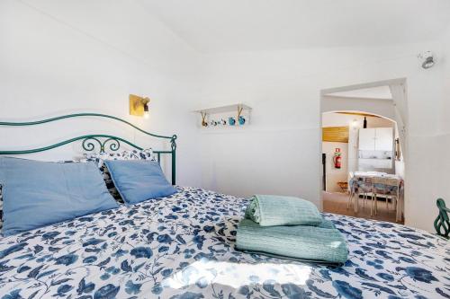 a bedroom with a bed with blue pillows on it at Abrigo do Pescador in Aljezur