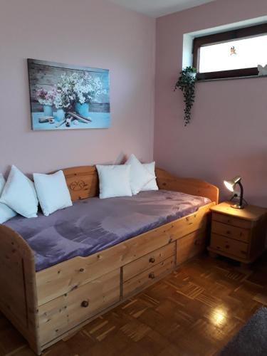 a bedroom with a wooden bed with pillows on it at Ferienwohnung 'unter Der Linde' in Neuenkirchen