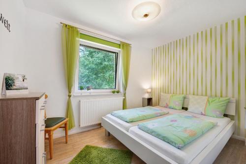 a small bedroom with a bed and a window at Fewo Birkenallee - Apfel in Deinste