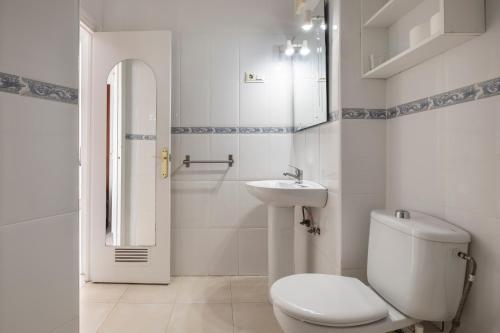 a white bathroom with a toilet and a sink at Estudio Bloque 80 in Torrox