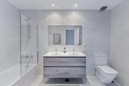 a bathroom with a sink and a toilet and a shower at Penthouse Jacaranda in Estepona