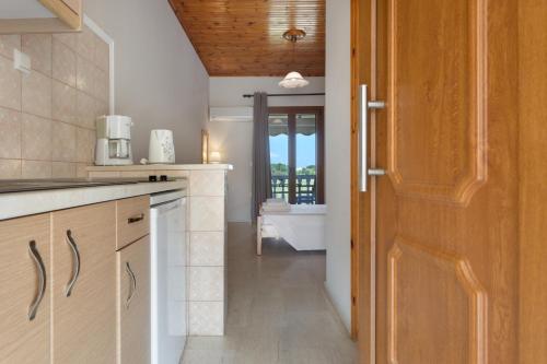 a kitchen with a door to a bathroom with a tub at Dimaras Apartments Zakynthos in Vasilikos