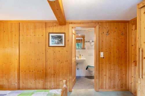 a bathroom with wood paneled walls and a toilet at Gasthaus Mamoosen in Penning