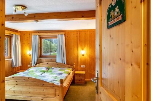 a bedroom with two beds in a wooden room at Gasthaus Mamoosen in Penning