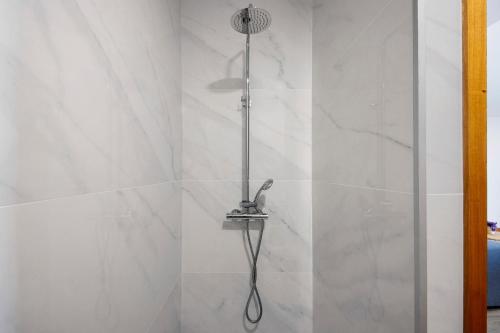 a shower with a shower head in a bathroom at Apartamento Lomi com Piscina in Apúlia