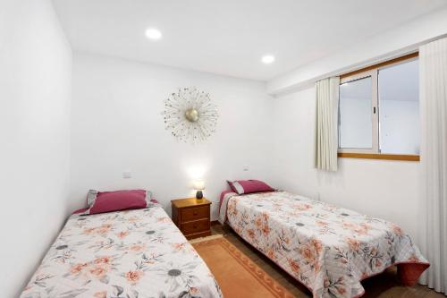 a bedroom with two beds and a window at Apartamento Lomi com Piscina in Apúlia