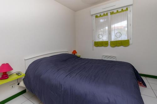a bedroom with a bed and a window at Appartement Fred in Moliets-et-Maa