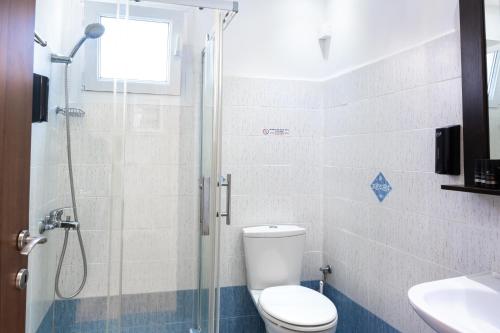 a bathroom with a shower and a toilet and a sink at Anemi Leros Apartments 1 in Panteli