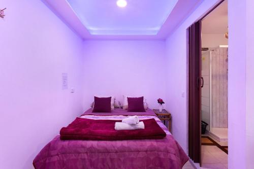 a bedroom with a large bed with a purple blanket at Luci's House B in São Jorge