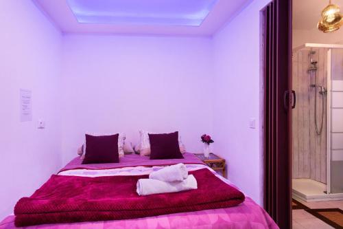 a bedroom with a large purple bed with purple sheets at Luci's House B in São Jorge