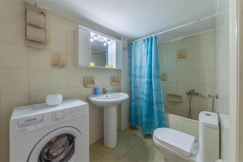 a bathroom with a washing machine and a sink at Virginia’s house in Andros