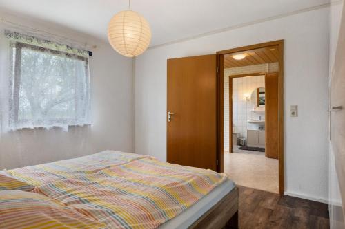 a bedroom with a bed and a hallway with a bathroom at Ferienwohnung Alberto in Drelsdorf