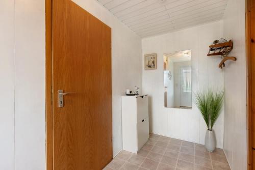 a hallway with a door and a plant in a vase at Ferienwohnung Alberto in Drelsdorf