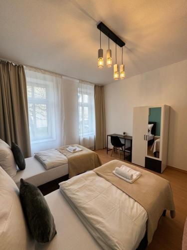 a hotel room with two beds and a desk at Arminos Apartment Li in Chemnitz