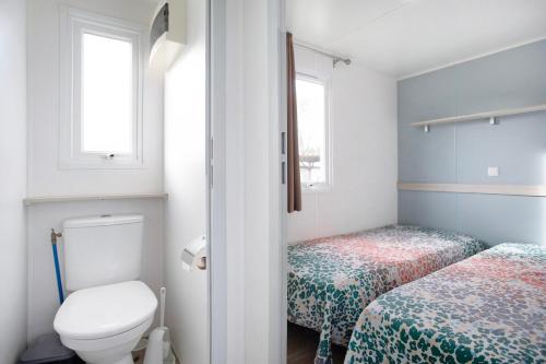 a small bathroom with two beds and a toilet at Bungalow T2 I - 15 Min From Nazaré in Pataias