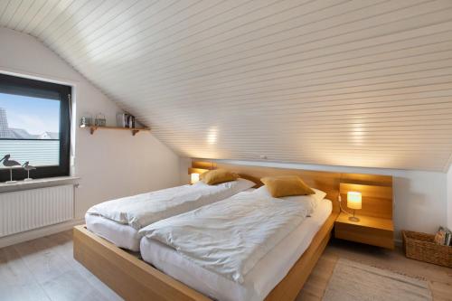 a large bed in a room with a large window at Ferienwohnung Helga Bauch in Klanxbüll