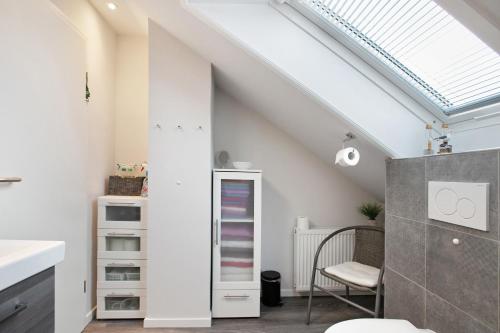 an attic bathroom with a skylight and a mirror at Ferienwohnung Helga Bauch in Klanxbüll