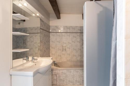 a bathroom with a sink and a bath tub at Les Sources Gîte La Grange in Chambonas