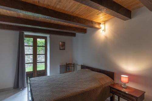 a bedroom with a bed and a window at Les Sources Gîte La Grange in Chambonas