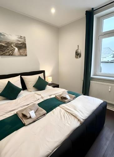 a bedroom with a large white bed with green accents at Altstadt-Oase 2 in Cottbus