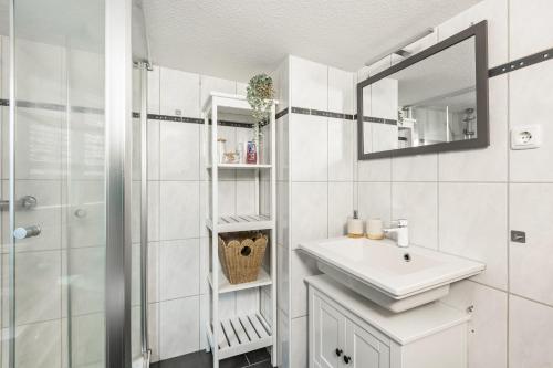 a white bathroom with a sink and a shower at Das Häuschen 1650 in Alsfeld