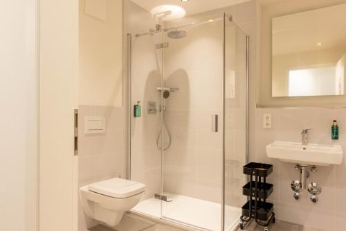 a bathroom with a shower and a toilet and a sink at AlegraStay Apartments - Dresden City in Dresden
