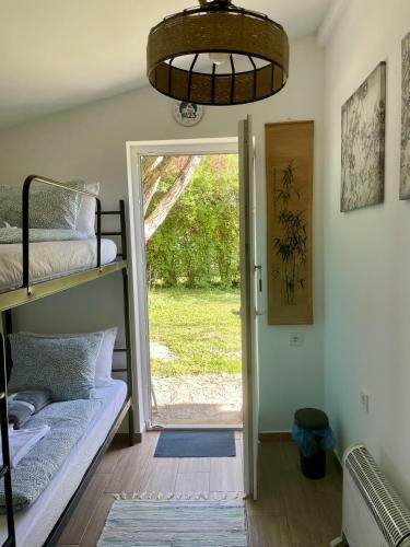 a room with bunk beds and a door to a yard at Cozy little hideaway in Balatonfüred